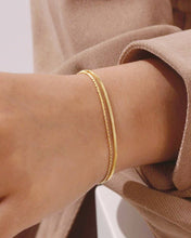 Load image into Gallery viewer, Gold bracelet on a person's wrist with a neutral background