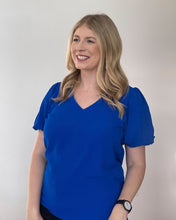 Load image into Gallery viewer, Woman wearing a short sleeve royal blue shirt with a v neck and puff sleeves