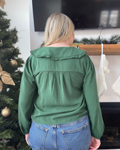 Load image into Gallery viewer, Person wearing a green blouse and blue jeans standing in front of a decorated Christmas tree.
