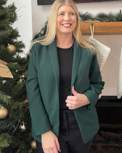 Load image into Gallery viewer, Woman in a green blazer standing in front of a Christmas tree
