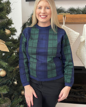 Load image into Gallery viewer, Woman wearing a blue and green plaid sweater standing in front of a decorated Christmas tree.
