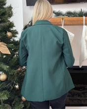 Load image into Gallery viewer, Person wearing a dark green blazer standing in front of a decorated Christmas tree.

