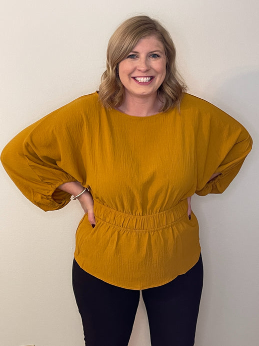 Woman in mustard color blouse with elastic waist